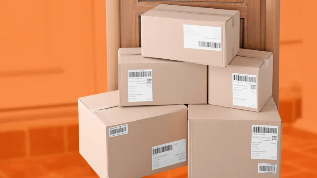 A pile of boxed packages of various sizes left on a stylized orange porch