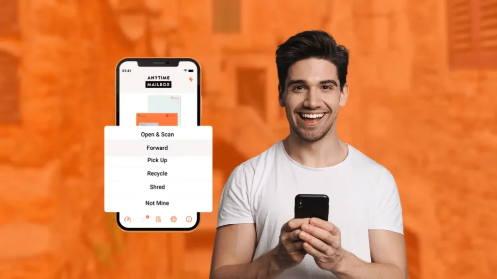 A man with dark hair smiles into the camera while using his phone, beside him is a phone showing the features of the Anytime Mailbox app as they are displayed on the home screen.