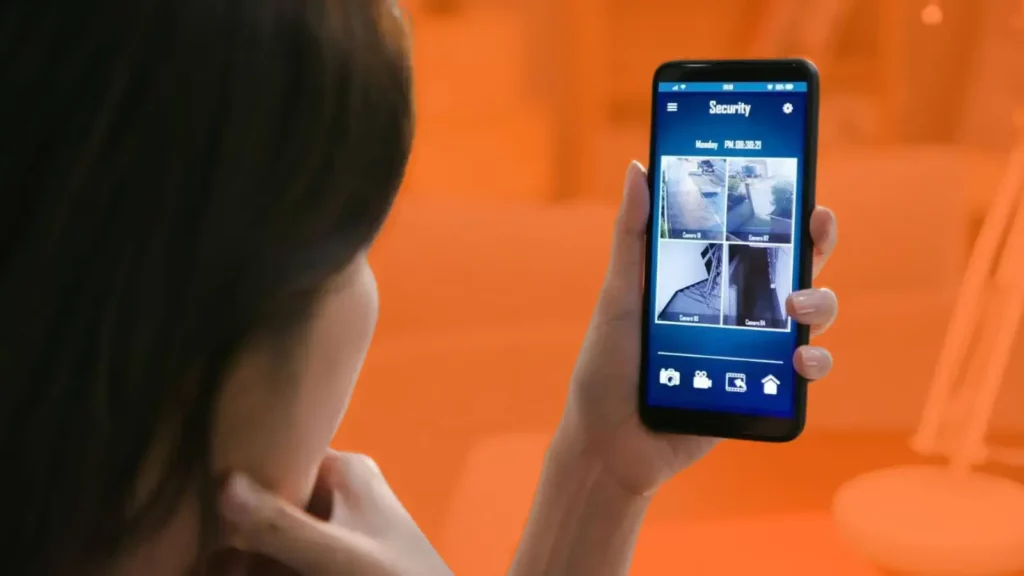 Woman looking at security camera footage on her phone.