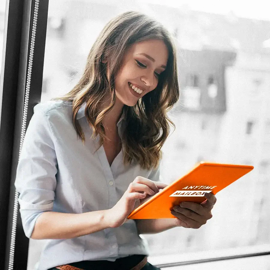 Smiling woman holding a tablet with an Anytime Mailbox label.